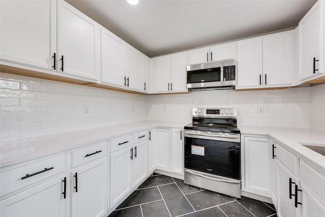 4320 Carmel Ave, Fort Worth, TX 76119 - kitchen featuring stainless steel appliances, light countertops, dark tile patterned floors, and white cabinets