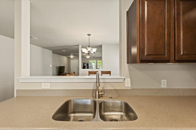 2352 Clairborne Dr, Fort Worth, TX 76177 - kitchen featuring a sink, light countertops, dark brown cabinets, pendant lighting, and a chandelier