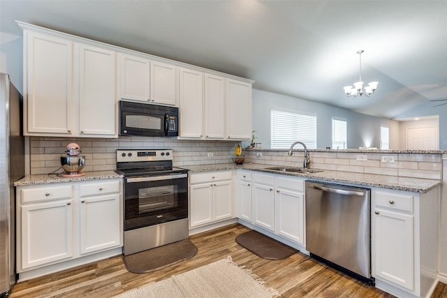 14320 Polo Ranch St, Fort Worth, TX 76052 - kitchen with appliances with stainless steel finishes, a sink, a peninsula, a chandelier, and light wood-style floors