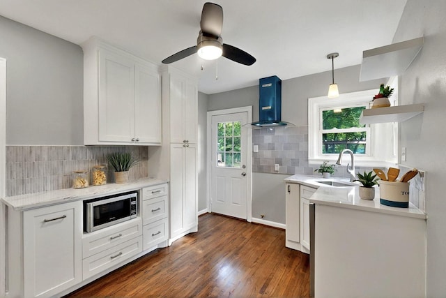 6042 Belgrade Ave, Dallas, TX 75227 - kitchen with wall chimney range hood, stainless steel microwave, a sink, open shelves, and white cabinetry