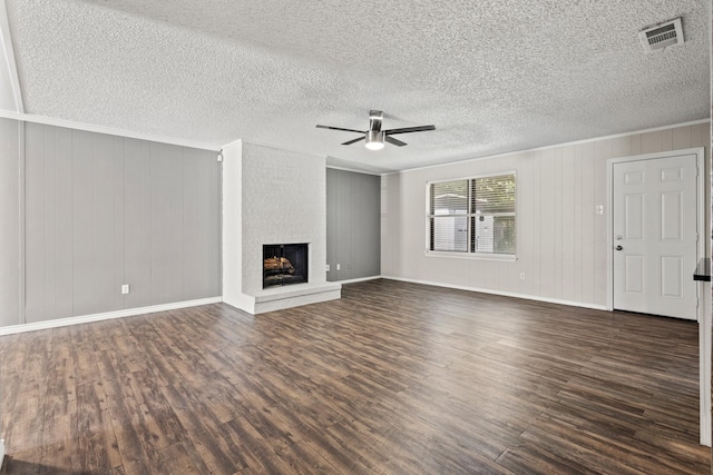 1530 Lime Leaf Ln, Duncanville, TX 75137 - unfurnished living room featuring ceiling fan, dark wood finished floors, a fireplace, baseboards, and a textured ceiling