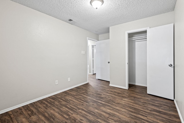 1530 Lime Leaf Ln, Duncanville, TX 75137 - unfurnished bedroom with dark wood-style floors, baseboards, and a textured ceiling