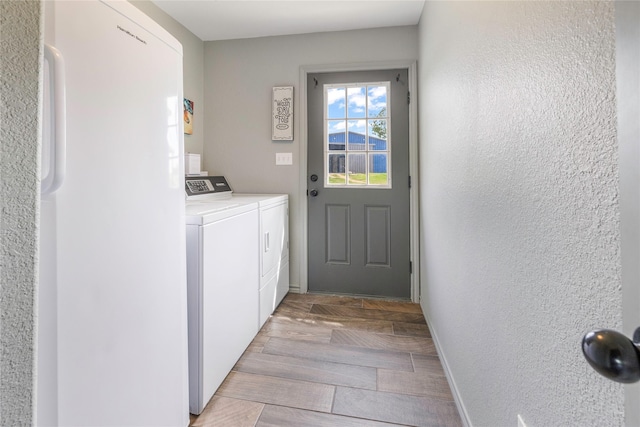1668 Poe Prairie Rd, Millsap, TX 76066 - laundry area with washing machine and dryer, a textured wall, and baseboards