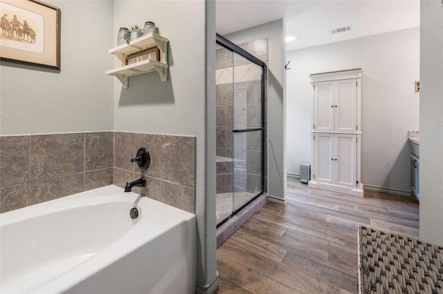 1668 Poe Prairie Rd, Millsap, TX 76066 - bathroom featuring a stall shower, a bath, wood finished floors, and vanity