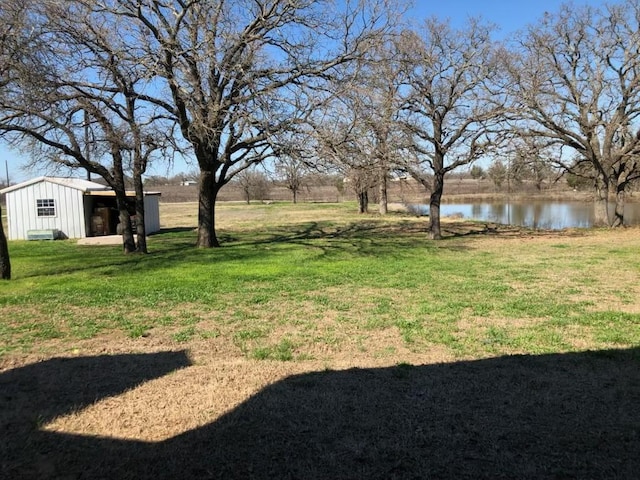 1668 Poe Prairie Rd, Millsap, TX 76066 - view of green lawn with a water view, an outbuilding, and a pole building