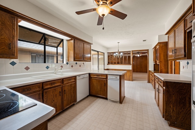 kitchen featuring dishwasher, a peninsula, ceiling fan, and a sink