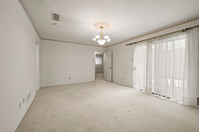 empty room with a chandelier, light carpet, and baseboards