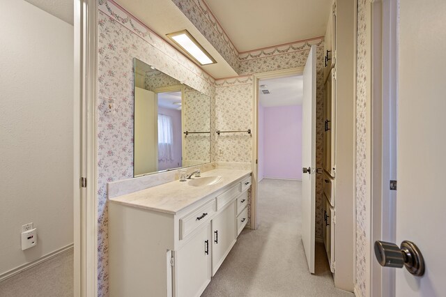 bathroom featuring wallpapered walls and vanity
