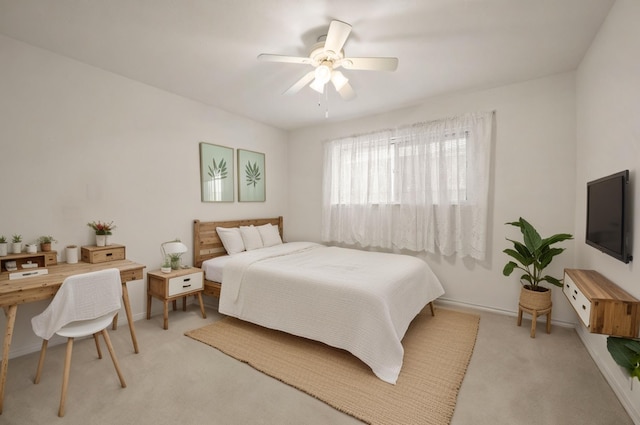 bedroom with light colored carpet, ceiling fan, and baseboards