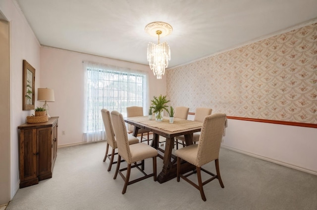 dining room with a chandelier, baseboards, and light colored carpet