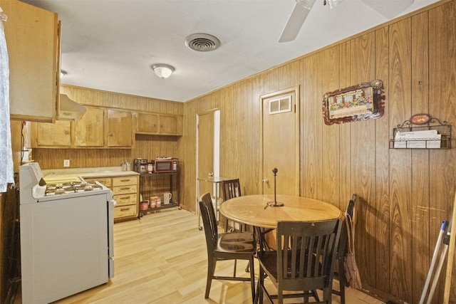 12015 Galva Dr, Dallas, TX 75243 - dining room with wooden walls, light wood-type flooring, and ceiling fan