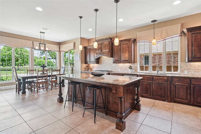 801 Shadow Hill Dr, Prosper, TX 75078 - kitchen with a sink, backsplash, light stone countertops, a kitchen island, and pendant lighting