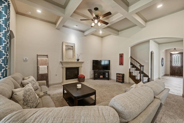 416 Fairway Bluff Dr, Wylie, TX 75098 - living room featuring arched walkways, beam ceiling, a ceiling fan, coffered ceiling, and a glass covered fireplace