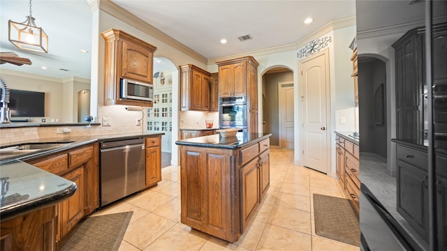 12046 Erin Ln, Fort Worth, TX 76179 - kitchen featuring stainless steel appliances, arched walkways, brown cabinetry, backsplash, and recessed lighting