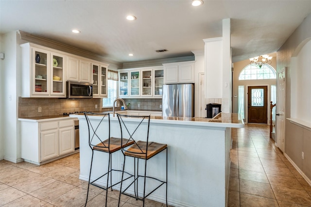 1414 Tulane Ct, Allen, TX 75013 - kitchen featuring stainless steel appliances, a breakfast bar, a chandelier, decorative backsplash, and recessed lighting