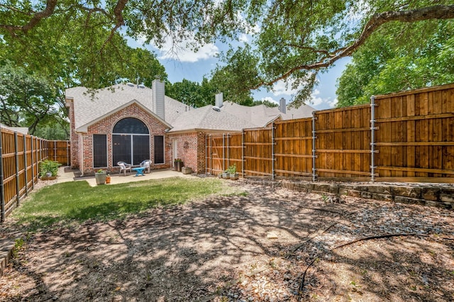 1414 Tulane Ct, Allen, TX 75013 - back of property with brick siding, a patio area, a fenced backyard, roof with shingles, and a chimney