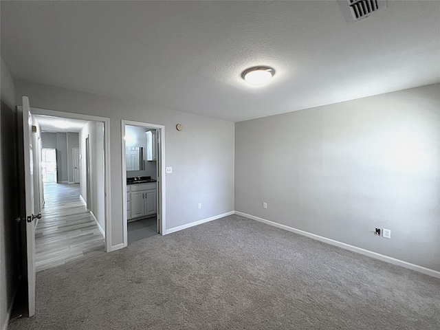 902 Mack Pl, Denton, TX 76209 - unfurnished bedroom featuring baseboards, dark colored carpet, and connected bathroom
