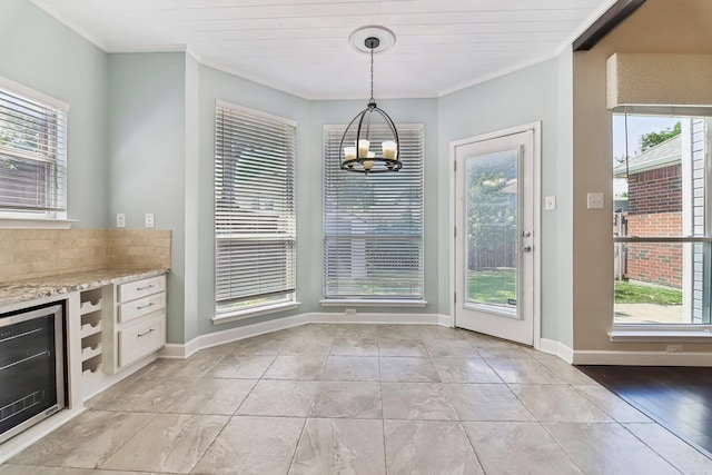 11003 Canoe Rd, Frisco, TX 75035 - unfurnished dining area with a chandelier, crown molding, baseboards, light tile patterned floors, and beverage cooler
