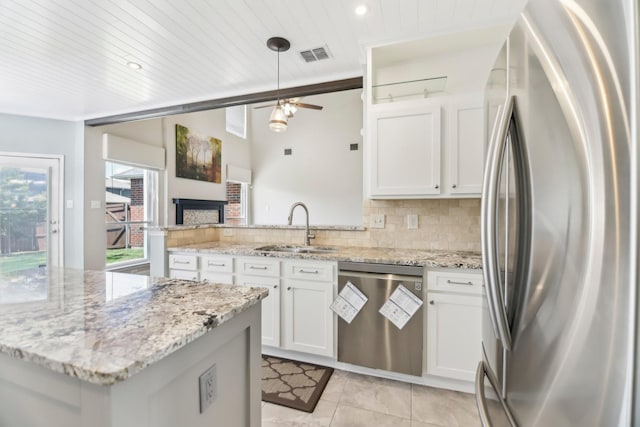 11003 Canoe Rd, Frisco, TX 75035 - kitchen featuring stainless steel appliances, a sink, a peninsula, white cabinets, and recessed lighting