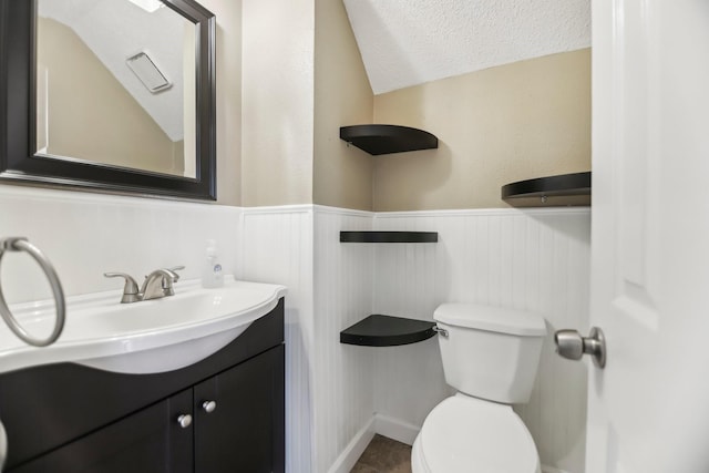 11003 Canoe Rd, Frisco, TX 75035 - half bathroom with a wainscoted wall, toilet, vanity, and a textured ceiling