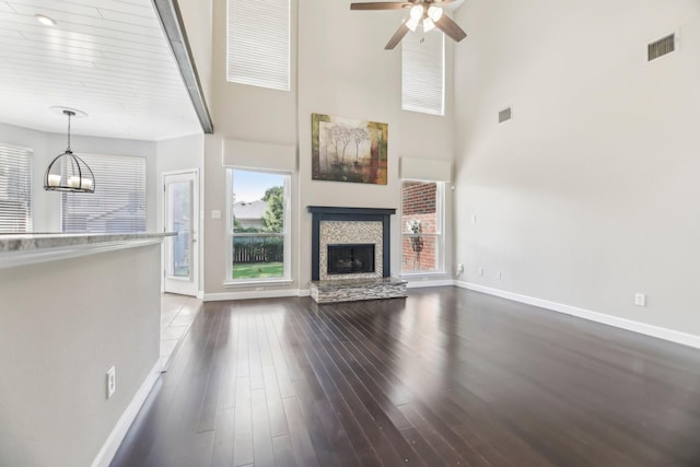 11003 Canoe Rd, Frisco, TX 75035 - unfurnished living room with plenty of natural light, baseboards, dark wood-type flooring, and a towering ceiling