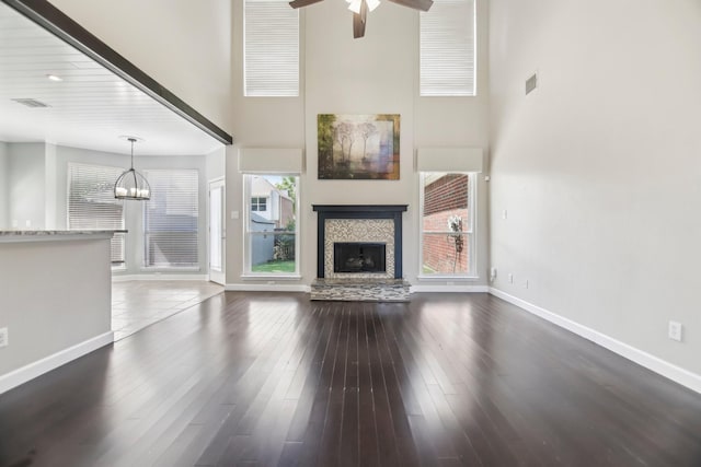11003 Canoe Rd, Frisco, TX 75035 - unfurnished living room with a high ceiling, a ceiling fan, a tiled fireplace, a chandelier, and baseboards