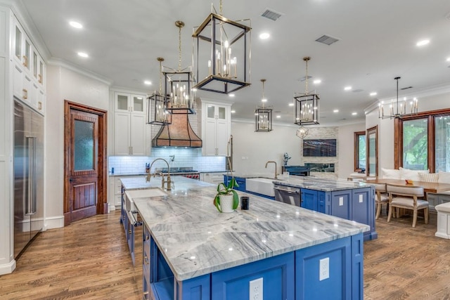 7212 John Mccain Rd, Colleyville, TX 76034 - kitchen with a large island, blue cabinets, ornamental molding, stainless steel appliances, and a sink