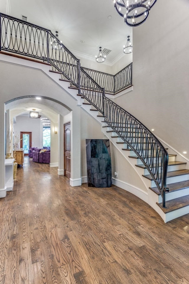 7212 John Mccain Rd, Colleyville, TX 76034 - stairs with arched walkways, a chandelier, wood finished floors, a high ceiling, and baseboards
