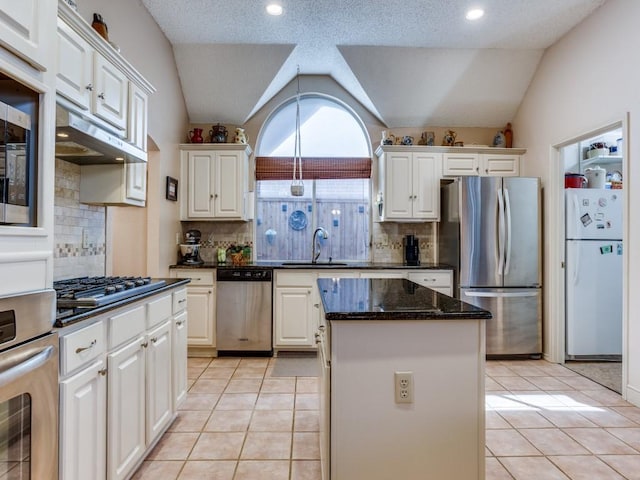 3214 Pecan Meadow Dr, Garland, TX 75040 - kitchen with stainless steel appliances, a sink, vaulted ceiling, a kitchen island, and light tile patterned floors