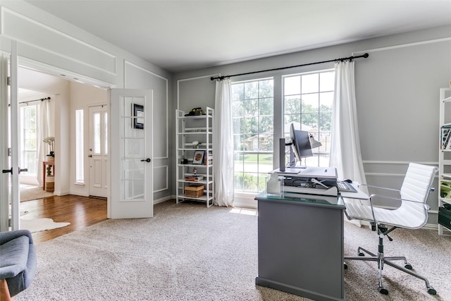 office space featuring french doors, healthy amount of natural light, and carpet