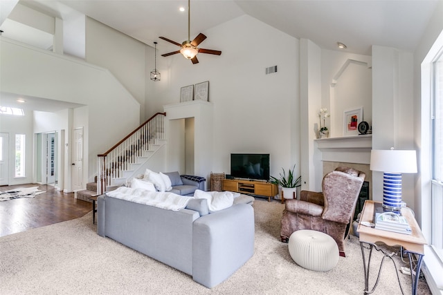 carpeted living area featuring stairs, high vaulted ceiling, healthy amount of natural light, ceiling fan, and recessed lighting