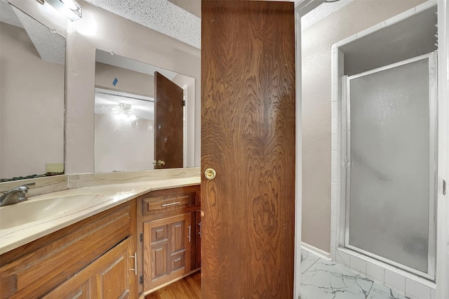 1717 Melrose St, Garland, TX 75042 - full bathroom with a stall shower, vanity, a textured ceiling, and marble look tiles