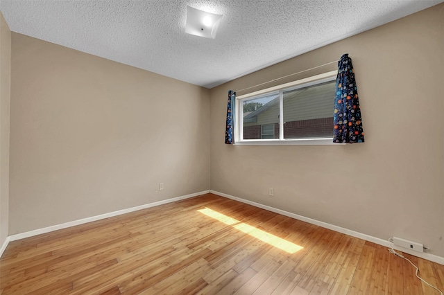 1717 Melrose St, Garland, TX 75042 - empty room featuring a textured ceiling, wood finished floors, and baseboards