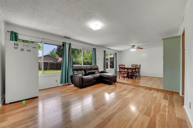 1717 Melrose St, Garland, TX 75042 - living area with a textured ceiling, ceiling fan, and light wood-style flooring