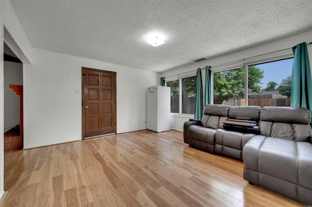 1717 Melrose St, Garland, TX 75042 - living area featuring a textured ceiling and light wood-style flooring