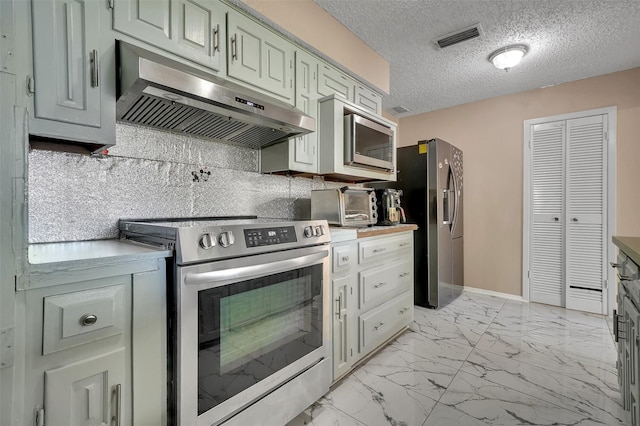 1717 Melrose St, Garland, TX 75042 - kitchen with stainless steel appliances, under cabinet range hood, light marble finish flooring, tasteful backsplash, and a textured ceiling