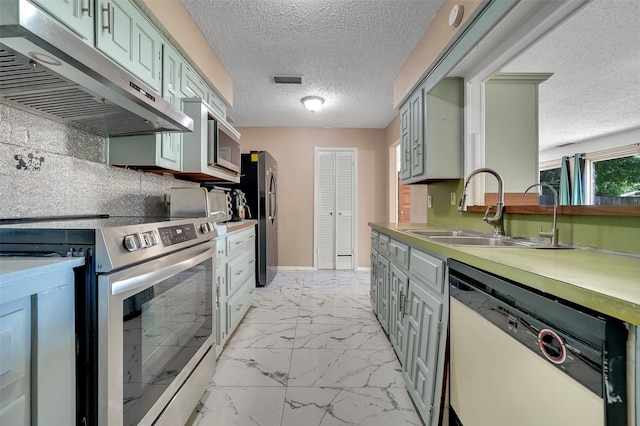 1717 Melrose St, Garland, TX 75042 - kitchen featuring stainless steel appliances, a sink, under cabinet range hood, light marble finish floors, and decorative backsplash