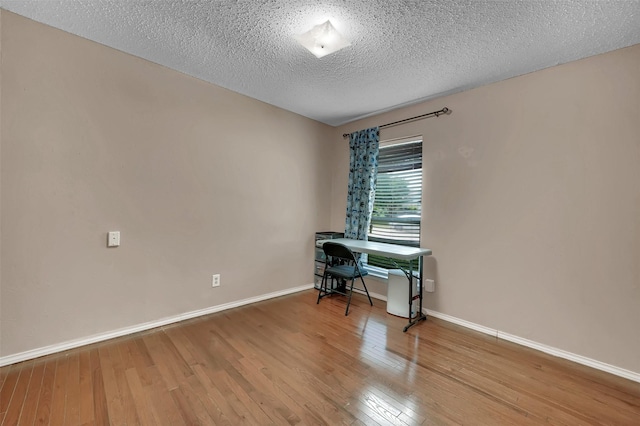 1717 Melrose St, Garland, TX 75042 - office area with wood finished floors, baseboards, and a textured ceiling
