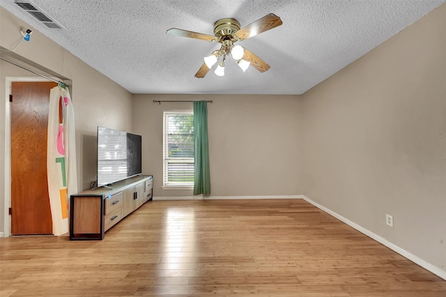 1717 Melrose St, Garland, TX 75042 - unfurnished living room with light wood-type flooring, a textured ceiling, a ceiling fan, and baseboards