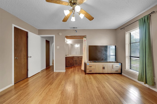 1717 Melrose St, Garland, TX 75042 - unfurnished living room featuring light wood finished floors, a textured ceiling, a ceiling fan, and baseboards