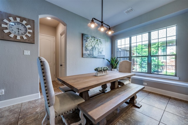 13348 Torrington Dr, Frisco, TX 75035 - dining room featuring a textured wall, arched walkways, baseboards, and tile patterned floors