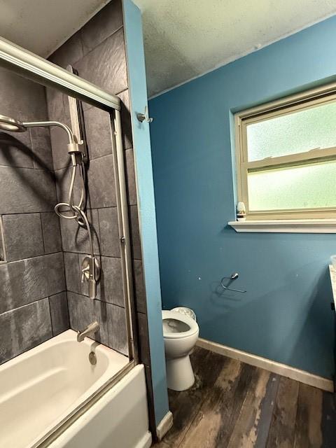 3524 Paramount St, North Richland Hills, TX 76117 - bathroom with toilet, wood finished floors, shower / bathtub combination, and baseboards