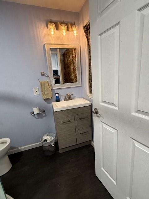 3524 Paramount St, North Richland Hills, TX 76117 - bathroom with vanity, toilet, baseboards, and wood finished floors