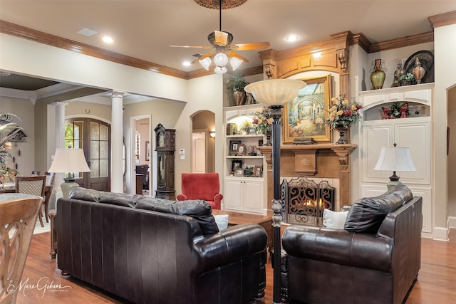 27 Wilshire Dr, Bossier City, LA 71111 - living room with ceiling fan, crown molding, wood finished floors, ornate columns, and a warm lit fireplace
