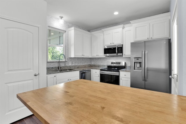 421 E Shepherd St, Denison, TX 75021 - kitchen featuring stainless steel appliances, a sink, white cabinetry, butcher block counters, and dark wood-style flooring