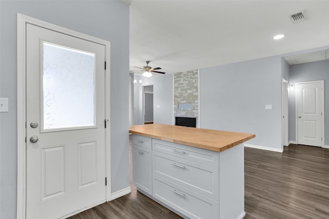 421 E Shepherd St, Denison, TX 75021 - kitchen with wood counters, baseboards, a fireplace, white cabinets, and ceiling fan
