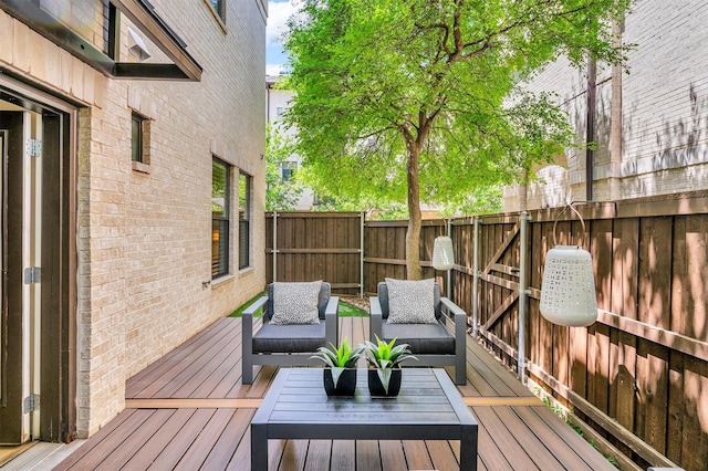 wooden terrace with outdoor lounge area and fence