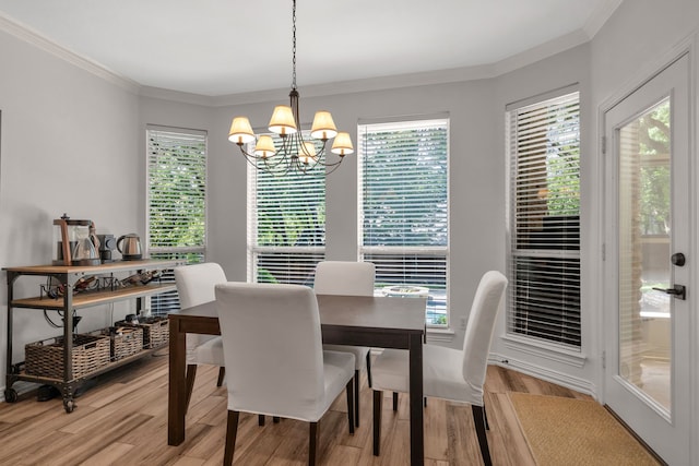 dining space with a chandelier, light wood-type flooring, plenty of natural light, and ornamental molding