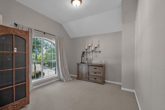unfurnished bedroom featuring carpet floors, baseboards, and lofted ceiling