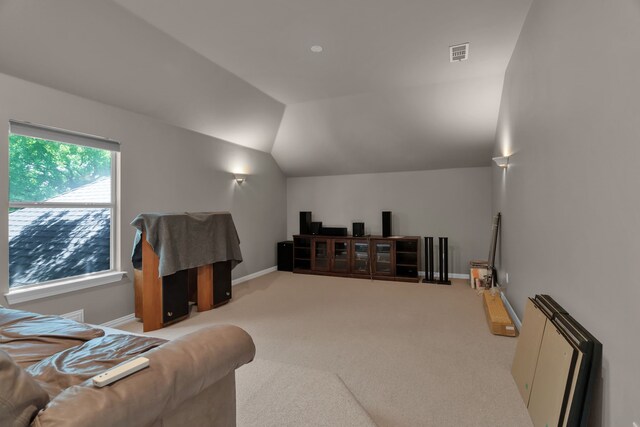 carpeted living area with vaulted ceiling and baseboards